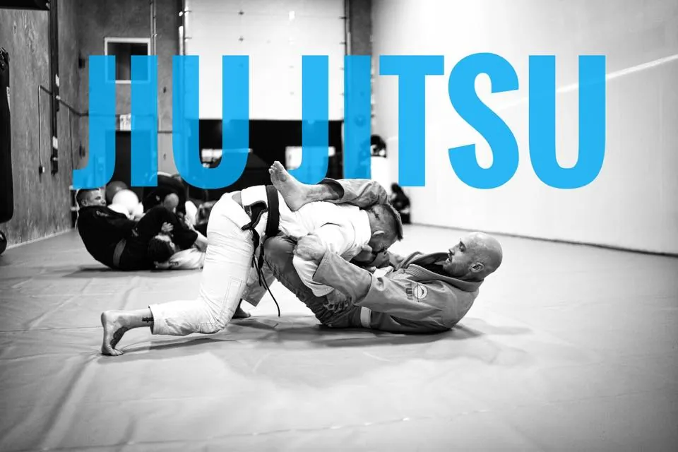 Black and white photograph of two grapplers rolling in gis at Mission BJJ
